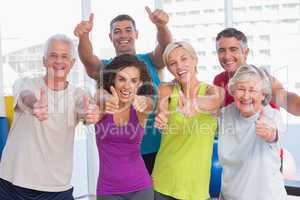Friends gesturing thumbs up in fitness club