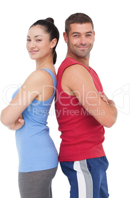 Fit man and woman smiling at camera together