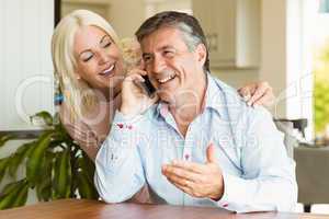 Happy mature couple using smartphone together