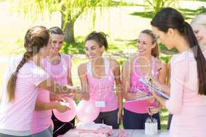 Smiling women organising event for breast cancer awareness