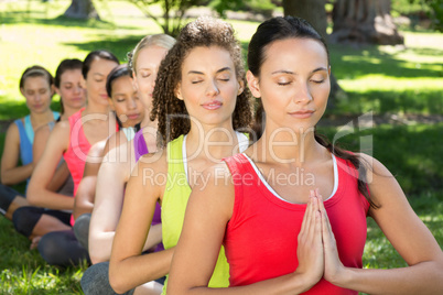 Fitness group doing yoga in park