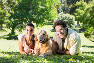 Happy couple with their dog in the park