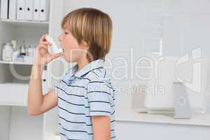 A little boy using inhaler