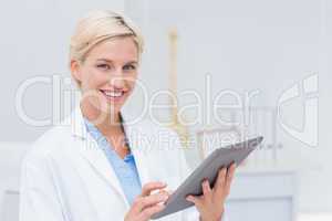 Confident female doctor using digital tablet