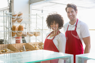 Portrait of happy co-workers standing behind the counter