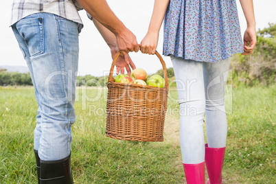 Couple holding basket full of apples