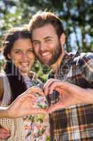 Young couple making heart with hands