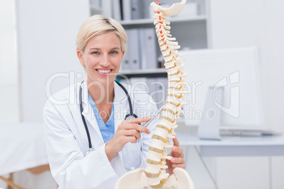 Female doctor with anatomical spine in clinic