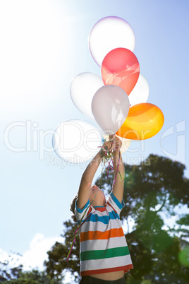 Happy little boy holding balloons