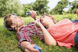 Cute couple in the park blowing bubbles