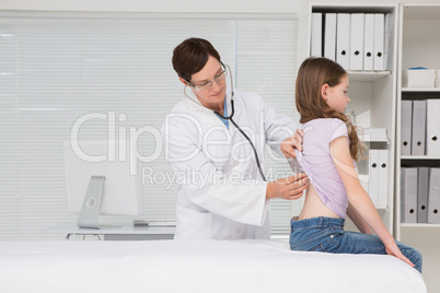 Doctor examining little girl