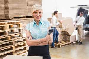 Warehouse manager holding scanner with arms crossed