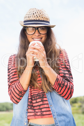 Pretty brunette in the park drinking coffee