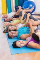People stretching legs in yoga class