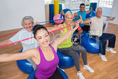 People exercising with resistance bands in gym