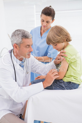 Doctor doing injection at little boy