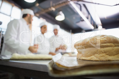 Fresh bread with bakers behind him