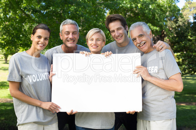 Happy volunteer family holding a blank