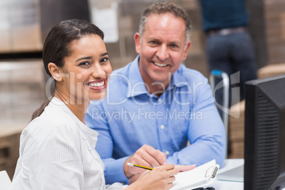 Smiling warehouse managers working together