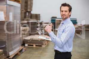 Warehouse manager smiling at camera showing thumbs up