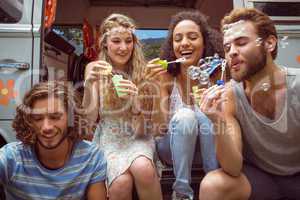 Hipsters blowing bubbles in camper van