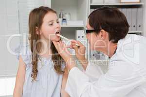 Doctor examining little girl mouth