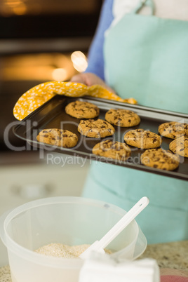 Woman showing tray of fresh cookies
