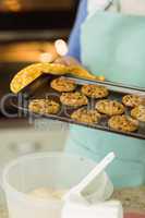 Woman showing tray of fresh cookies