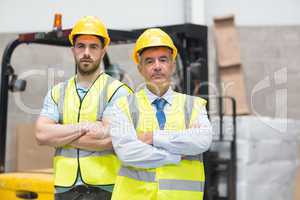 Manager with arms crossed and his colleague behind him