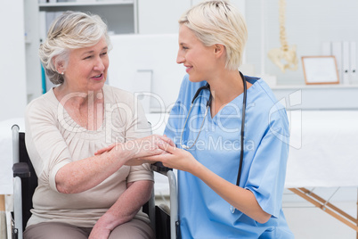 Female nurse checking flexibility of patients wrist