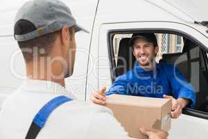 Delivery driver handing parcel to customer in his van