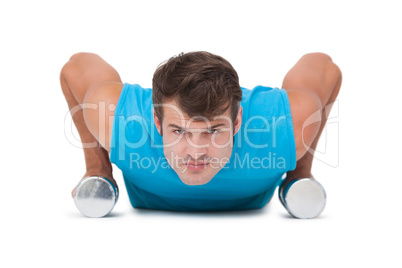 Fit man doing push ups with dumbbells