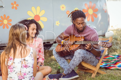 Hipster playing guitar for his friends