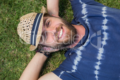 Handsome hipster lying on grass