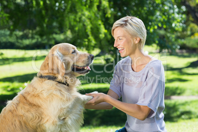Pretty blonde playing with her dog in the park