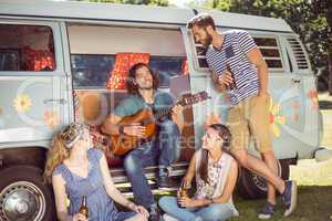 Hipster playing guitar for his friends