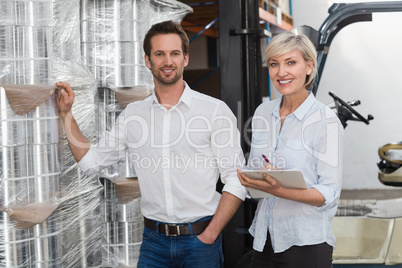 Smiling warehouse managers checking inventory