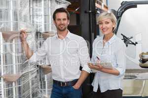 Smiling warehouse managers checking inventory