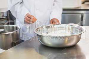 Baker making dough with eggs and flour