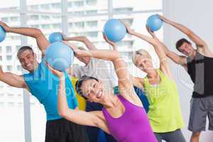 Instructor with class exercising with fitness balls