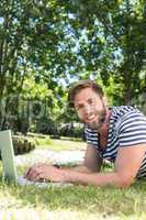 Hipster using laptop in the park