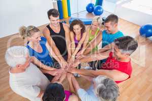 Fit people stacking hands at health club