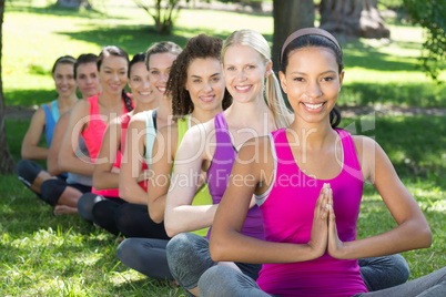 Fitness group doing yoga in park