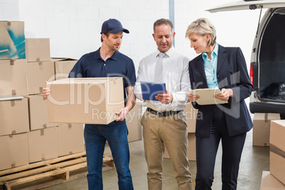 Delivery driver checking his list on tablet with managers