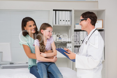 Doctor examining little girl with her mother