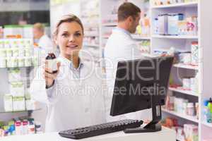Pharmacist showing medicine bottle