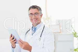 Confident male doctor using tablet computer