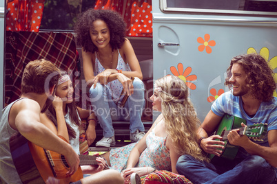 Hipster friends by camper van at festival
