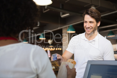 Customer paying by credit card her bread