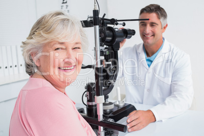 Senior woman smiling while sitting with optician